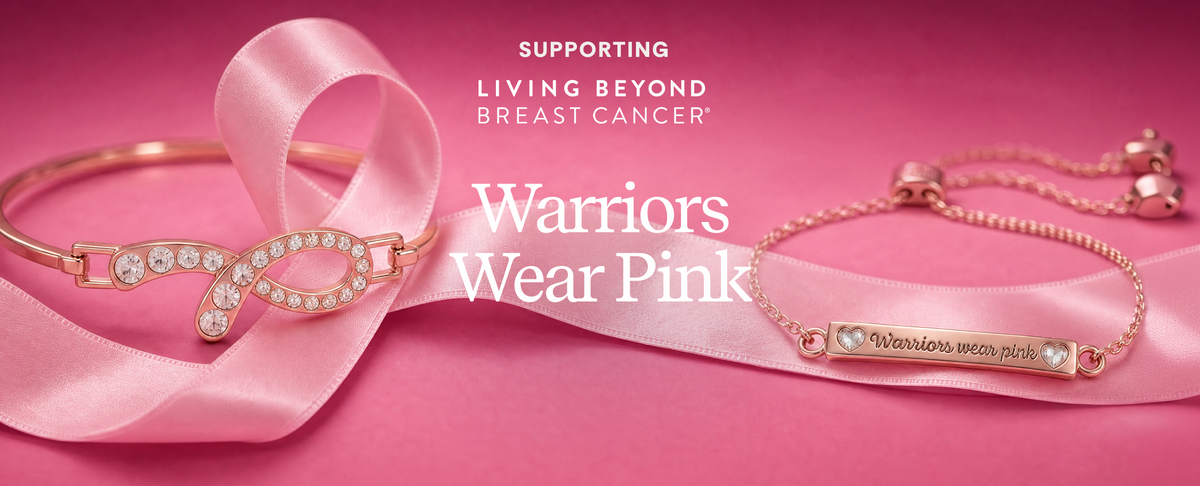 Two pink and rose gold breast cancer awareness bracelets displayed on a pink satin ribbon, with text overlays reading 'SUPPORTING LIVING BEYOND BREAST CANCER' and 'Warriors Wear Pink'.