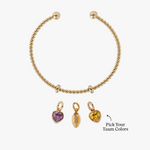 Silver bracelet with three charms on a white background