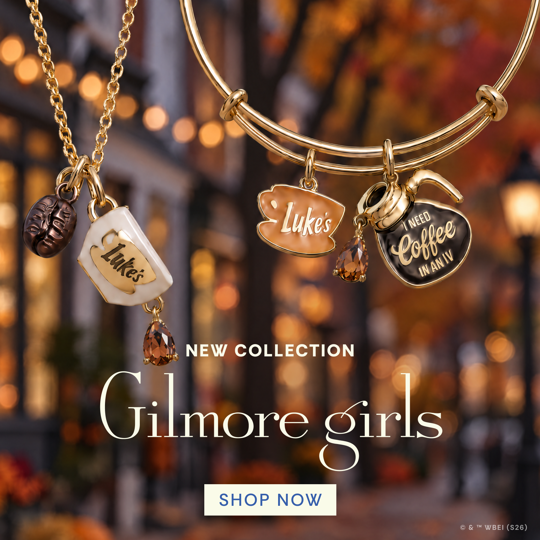 Gold-toned jewelry set with coffee-themed charms, including a necklace with a coffee cup charm and bangles with coffee cup and heart charms, shown against a blurred autumn street background with the text 'NEW COLLECTION' and 'Gilmore girls'.