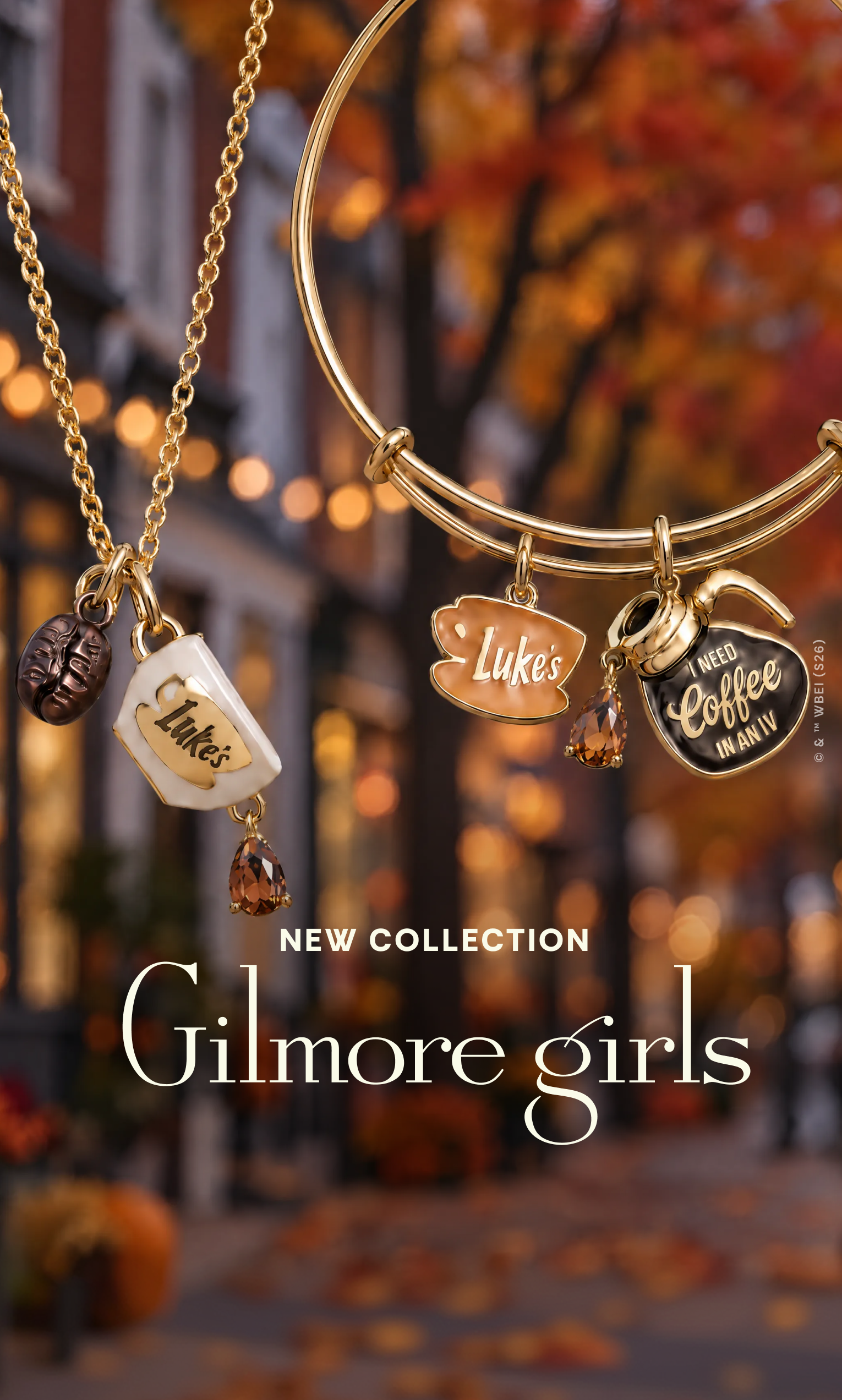 Gold-toned jewelry set with coffee-themed charms, including a necklace with a coffee cup charm and bangles with coffee cup and heart charms, shown against a blurred autumn street background with the text 'NEW COLLECTION' and 'Gilmore girls'.