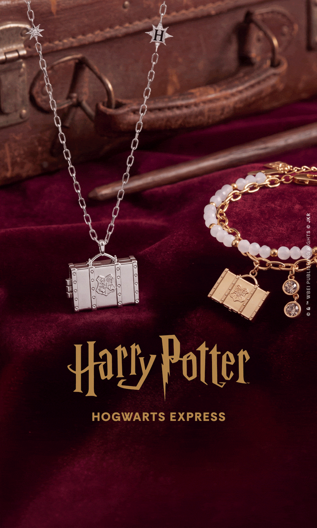 A promotional banner for Harry Potter: The Forbidden Journey featuring a dark red velvet background, the gold and purple Harry Potter logo, and several jewelry items including a silver book charm, a pearl necklace with a gold pendant, and a gold key charm.