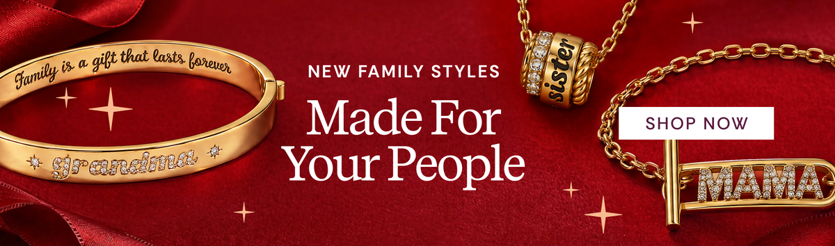 Gold family-style jewelry set on a red satin background with promotional text. The set includes a bracelet engraved with 'Family is a gift that lasts forever' and 'janaana', a cylindrical charm engraved 'Lover', and a T-bar necklace with 'MAMA' crystal accents and a gold bar ending in 'ister'.
