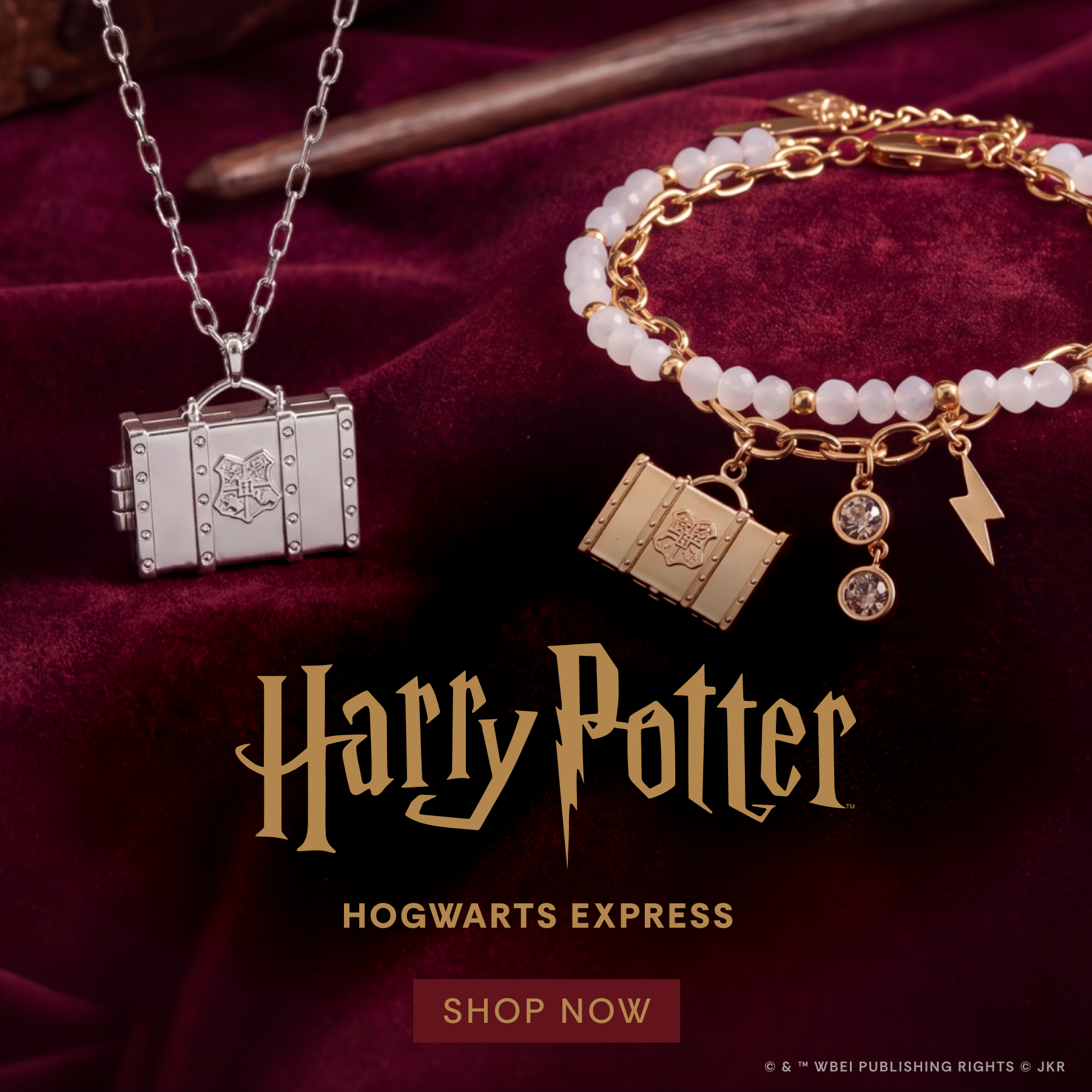 A promotional product display featuring a silver Harry Potter Hogwarts Express necklace with a trunk-shaped pendant and a gold-toned bracelet with book, lightning bolt, and crystal charms. The jewelry is arranged on a deep burgundy velvet fabric background with a wooden wand prop, and the text 'Harry Potter', 'Hogwarts Express', and 'SHOP NOW' is overlaid.