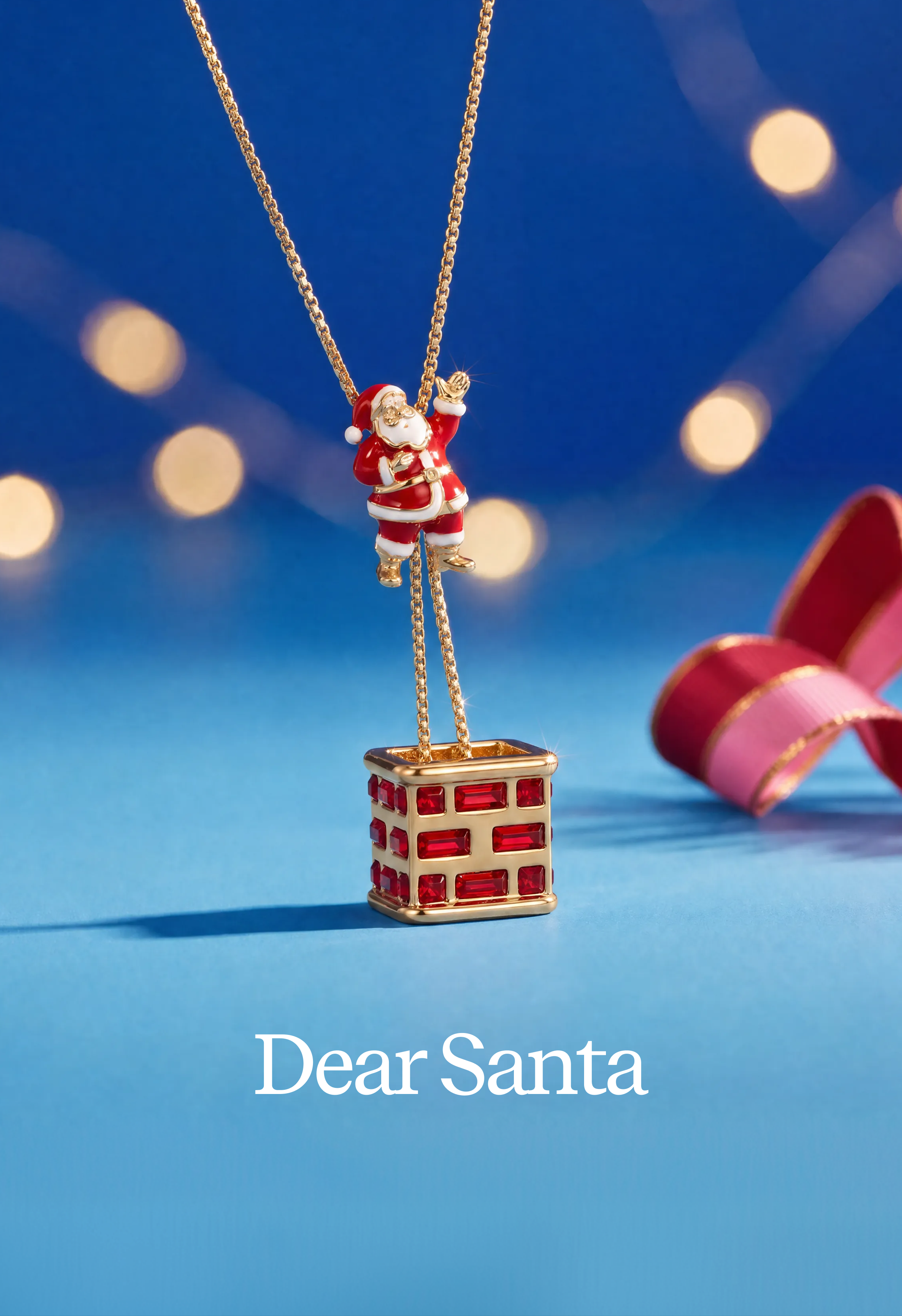 A gold-tone Christmas pendant necklace featuring a small Santa Claus figure hanging from a brick chimney. The necklace is displayed on a blue background with festive bokeh lights and a pink ribbon, with the text 'Dear Santa' at the bottom.