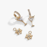 Gold-toned cocktail-themed jewelry set featuring two martini glass earrings with clear gemstone details and two matching snowflake charms, displayed on a clean white background.