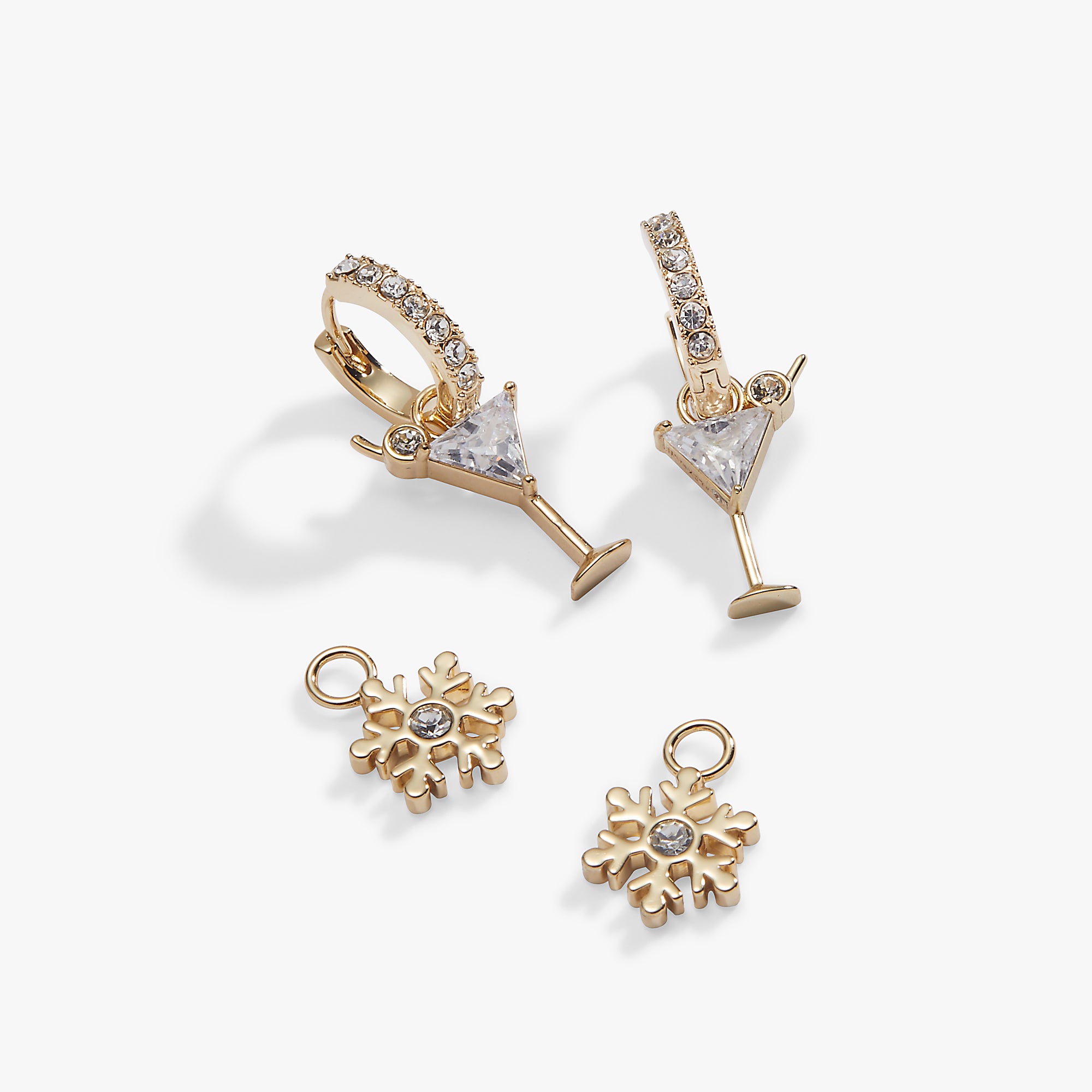 Gold-toned cocktail-themed jewelry set featuring two martini glass earrings with clear gemstone details and two matching snowflake charms, displayed on a clean white background.