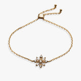 A gold chain bracelet with an adjustable sliding clasp and a central flower-shaped charm set with clear rhinestones, shown on a plain white background.