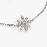 A silver-toned snowflake pendant necklace with clear baguette and round crystals, displayed on a clean white background.