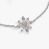 A silver-toned snowflake pendant necklace with clear baguette and round crystals, displayed on a clean white background.