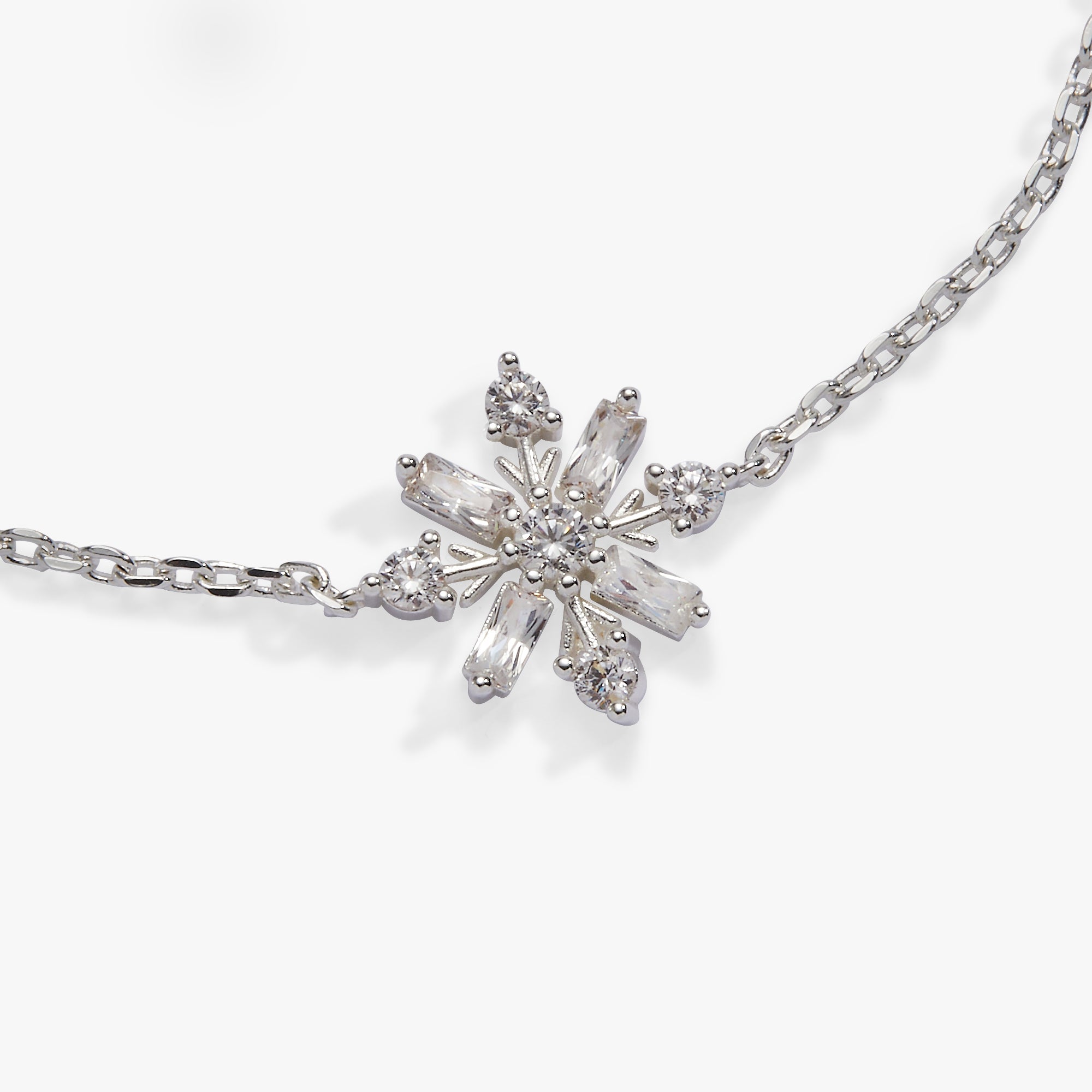 A silver-toned snowflake pendant necklace with clear baguette and round crystals, displayed on a clean white background.