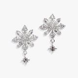A pair of silver snowflake-shaped drop earrings with clear faceted crystals and small dangling star charms, shown on a clean white background.