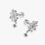 A pair of silver snowflake stud earrings with dangling star charms, set with clear crystals on a light gray background.