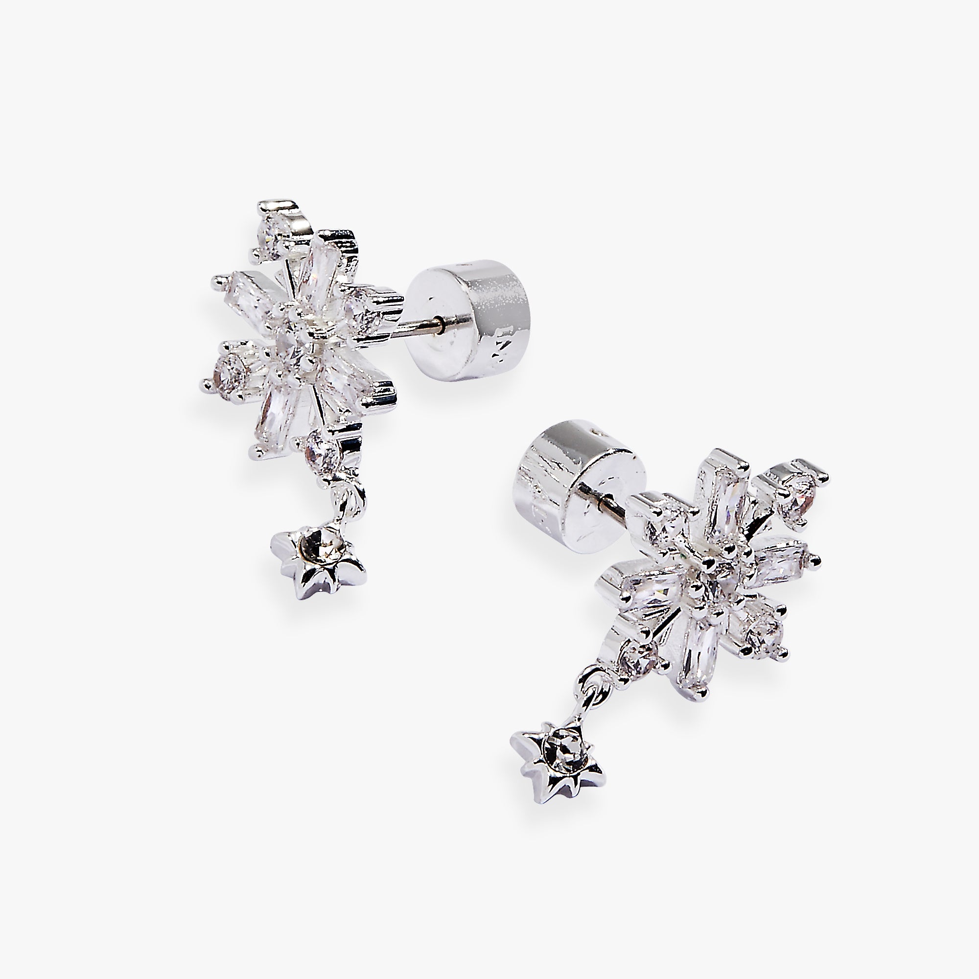 A pair of silver snowflake stud earrings with dangling star charms, set with clear crystals on a light gray background.