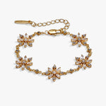 A gold-tone bracelet featuring five starburst flower motifs set with clear crystals, displayed on a clean white background.