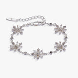A silver-toned bracelet featuring five snowflake-shaped crystal clusters, a matching extender chain, and a lobster clasp, displayed on a clean white background.