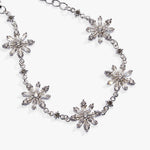 A silver-tone chain necklace featuring five large, clear faceted crystal snowflake motifs spaced along the chain, photographed on a clean white background.