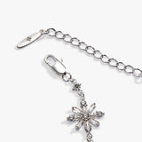 Silver-tone chain extender with a lobster clasp and a dangling snowflake charm embellished with clear rhinestones, shown on a light gray background.