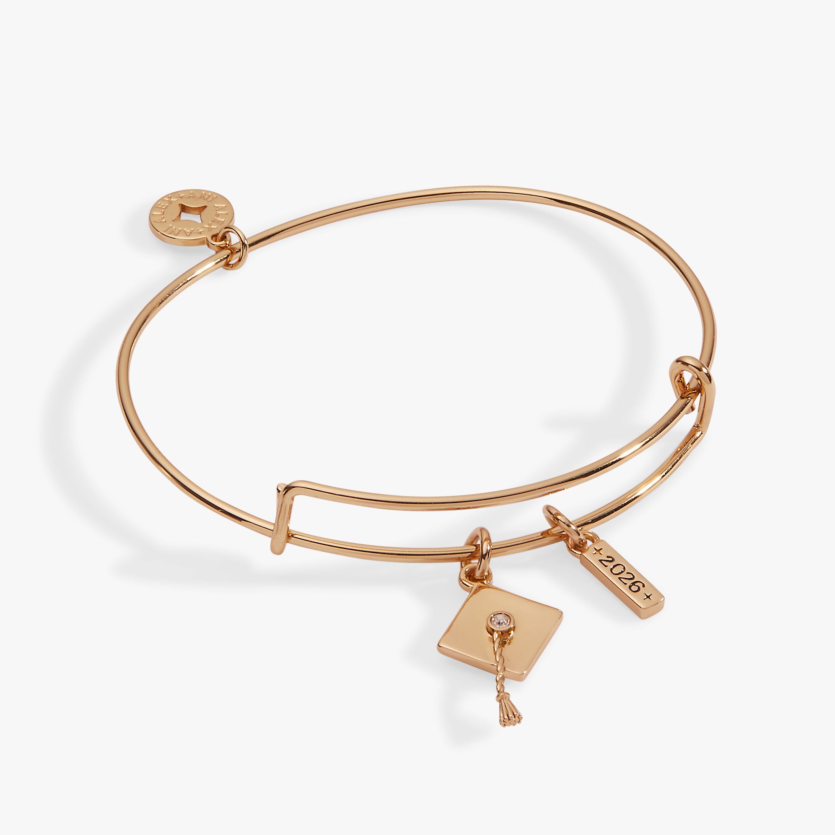 A gold bangle bracelet with a graduation cap and a year charm
