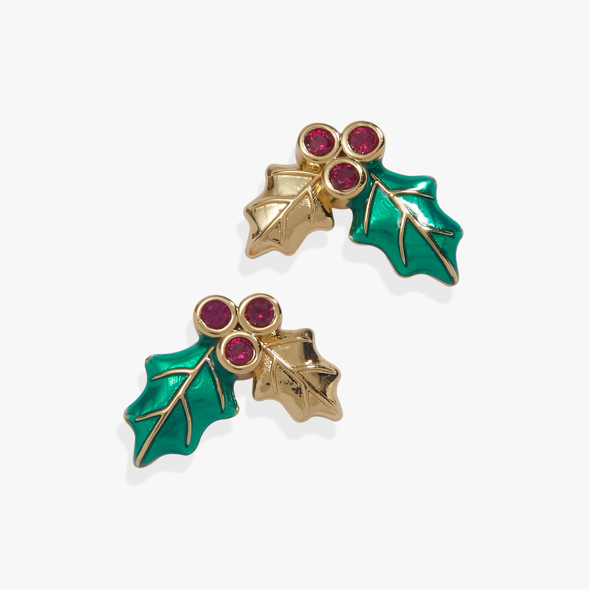 A pair of gold-tone holly leaf stud earrings with vibrant green enamel leaves and three small round pink gemstones at the top, set against a clean white background.