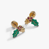 A pair of gold holly stud earrings with green enamel leaves and small red gemstone berries, shown on a clean white background.