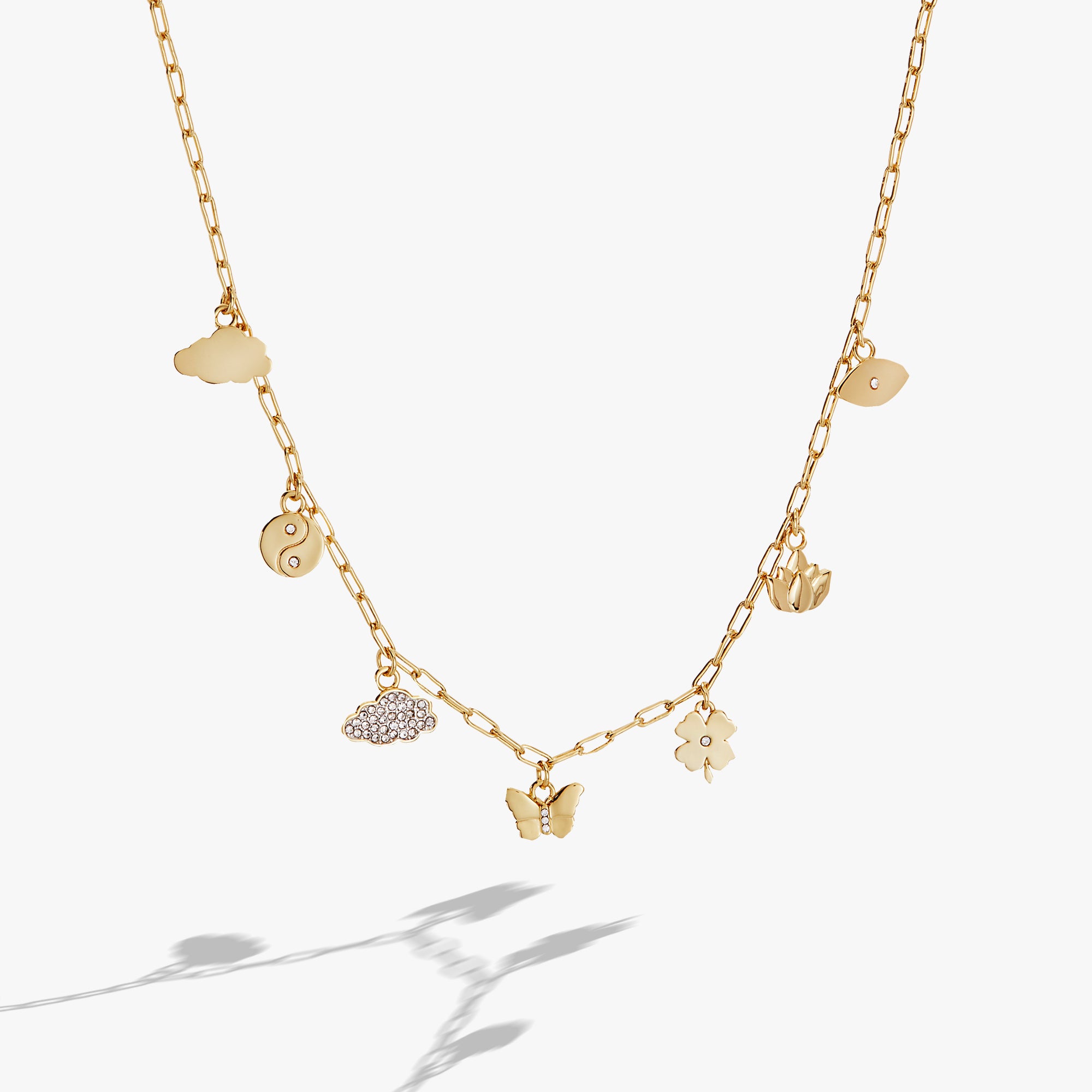 A gold chain necklace with six charms on it
