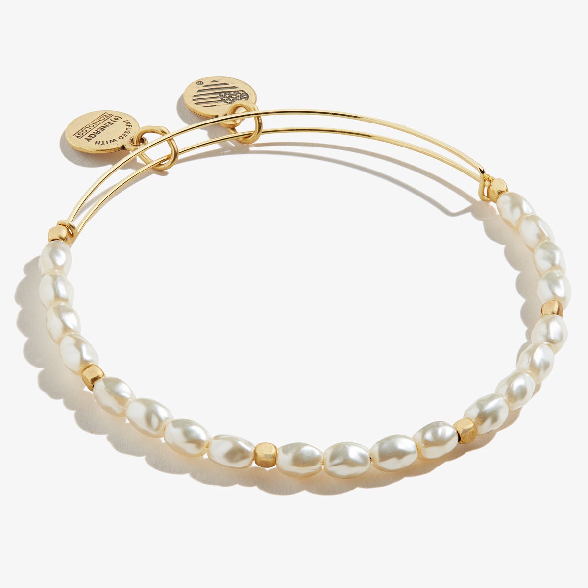A gold bracelet with two charms and pearl beads